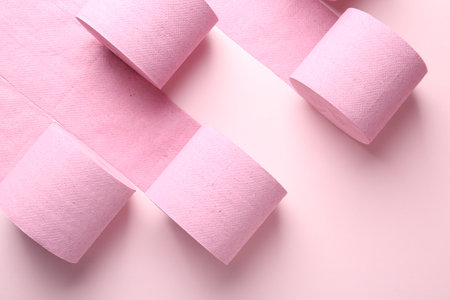 Color toilet paper rolls on light pink background, flat layの写真素材