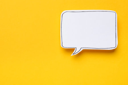 Blank speech bubble on yellow background, top view. Space for textの写真素材
