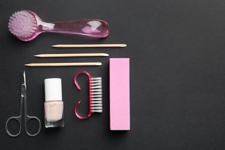Set of pedicure tools on black background, flat lay. Space for textの写真素材