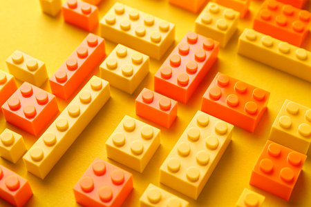 Constructor toy. Many building blocks on yellow background, closeupの写真素材