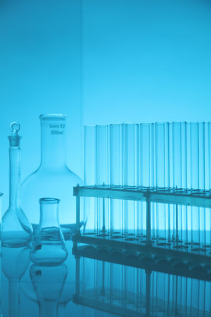 Laboratory glassware on mirror surface against light blue backgroundの写真素材