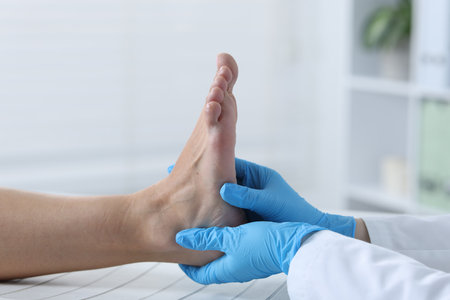 Doctor examining patient's foot in hospital, closeupの写真素材