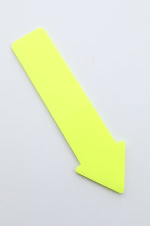 One yellow paper arrow isolated on white, top view