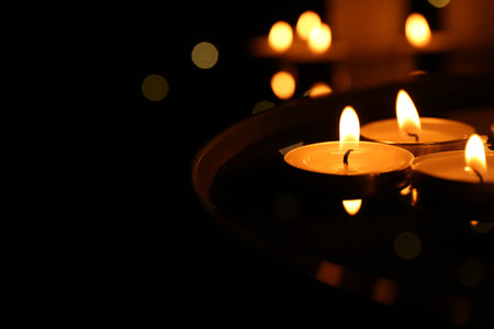 Burning candles on dark surface, closeup. Space for textの写真素材