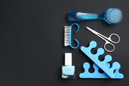 Set of pedicure tools on black background, flat lay. Space for textの写真素材
