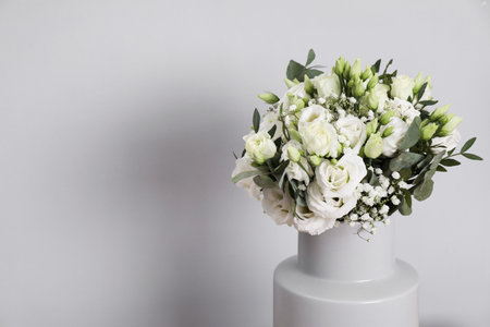 Wedding bouquet of beautiful flowers in vase against grey wall, closeup. Space for textの写真素材