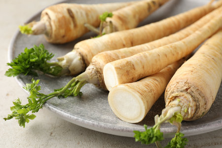 Whole and cut fresh parsley roots on gray table, closeupの写真素材