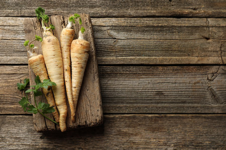 Raw parsley roots with leaves on wooden table, top view. Space for textの写真素材