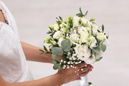 Bride with beautiful wedding bouquet on light background, closeupの写真素材