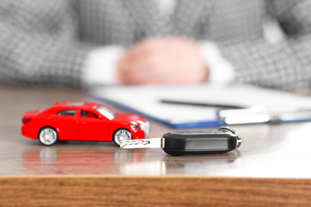 Car model and key on wooden table, selective focus. Buying autoの写真素材