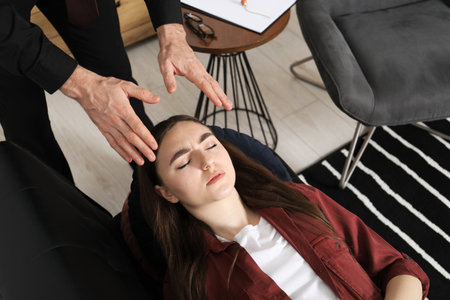 Psychologist working with patient during hypnosis session indoors, above viewの写真素材