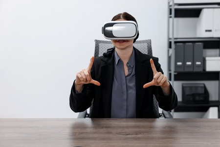 Woman using virtual reality headset in officeの写真素材