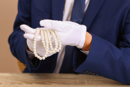 Appraiser with luxury jewelry at wooden table, closeupの写真素材