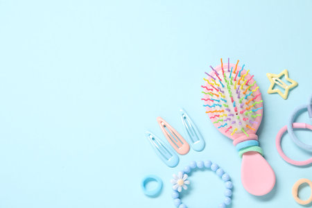 Different hair accessories and brush on light blue background, flat lay. Space for textの写真素材