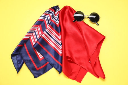 Stylish handkerchiefs and sunglasses on yellow background, flat layの写真素材