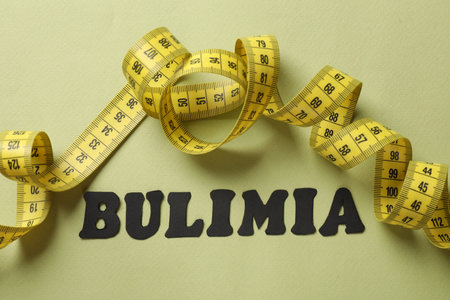 Word Bulimia and measuring tape on olive background, top viewの写真素材