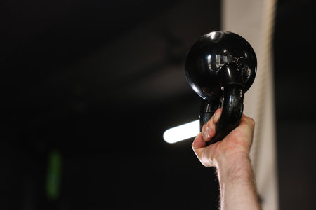 Sportsman with kettlebell during workout in gym, closeup. Space for textの写真素材