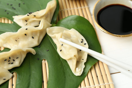 Tasty boiled gyoza (dumplings) served on white wooden table, closeupの写真素材