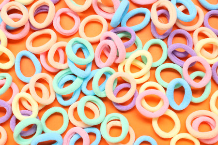 Colorful hair ties on orange background, flat layの写真素材