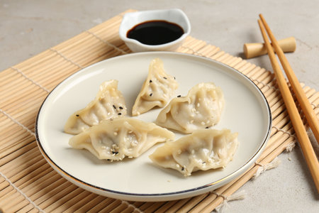 Delicious gyoza dumplings with sesame seeds served on light table, closeupの写真素材