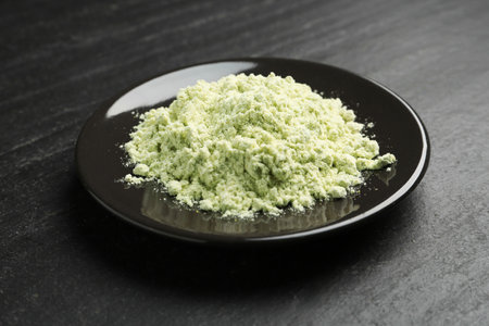 Plate with dry wasabi powder on dark textured table, closeupの写真素材