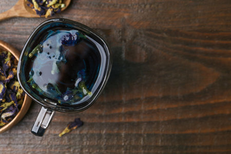 Delicious butterfly pea flower tea on wooden table, flat lay. Space for textの写真素材