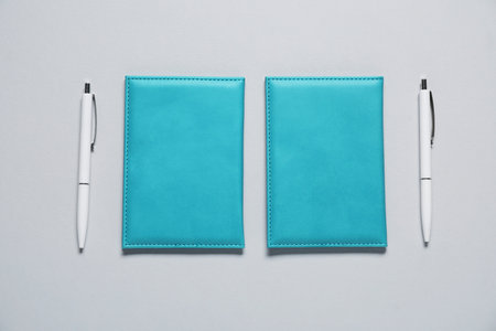 Blank covers and pens on gray background, flat lay. Mockup for design