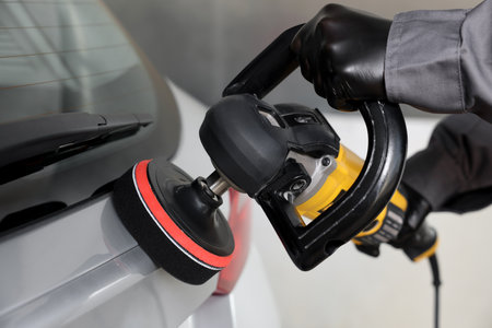 Man polishing car with orbital polisher indoors, closeupの写真素材