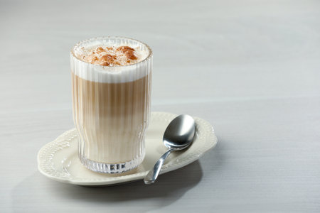 Tasty latte macchiato in glass on white table, space for text. Coffee drinkの写真素材