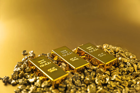Gold nuggets and bars on shiny background, closeup