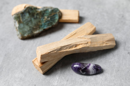 Palo santo sticks and gemstones on gray table, closeupの写真素材