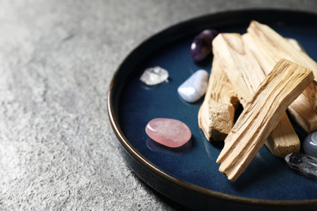 Palo santo sticks and gemstones on grey table, closeupの写真素材