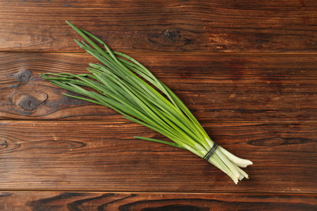 Bunch of fresh green onions on wooden table, top viewの写真素材