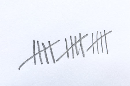 Counting days by drawing sticks with pencil on white background, closeupの写真素材