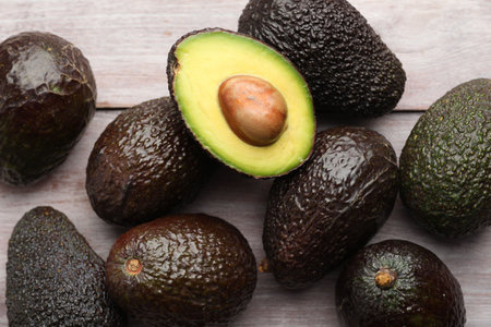 Fresh ripe avocados on light wooden table, closeupの写真素材