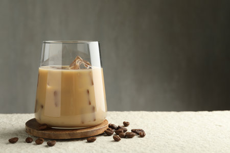 Coffee cream liqueur in glass and beans on white textured table, space for textの写真素材