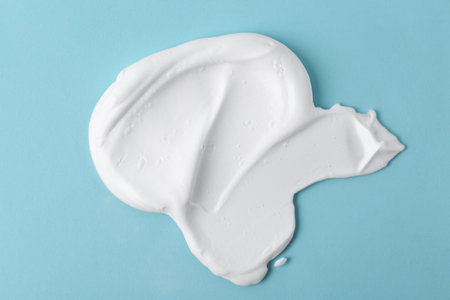 Sample of fluffy foam on light blue background, top viewの写真素材