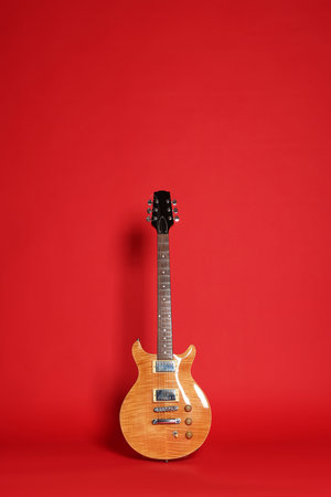 One modern electric guitar on red background