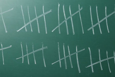 Counting days by drawing sticks with chalk on chalkboard, closeupの写真素材
