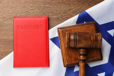 Passport in red cover, gavel and flag of Israel on wooden table, top viewの写真素材
