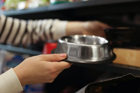 Woman choosing feeding bowl in pet shop, closeupの写真素材