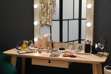 Makeup room. Wooden dressing table with mirror and different beauty products indoorsの写真素材
