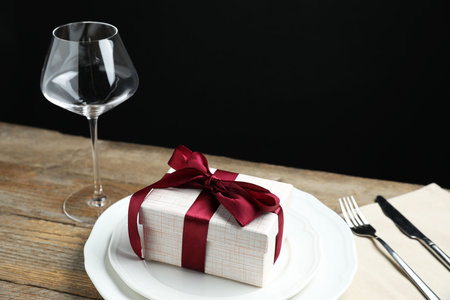 Beautiful table setting with romantic gift on wooden backgroundの写真素材