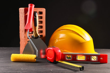 Different construction material and tools on black table