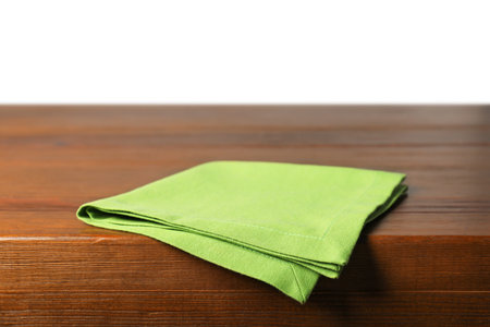 Green napkin on wooden table against white backgroundの写真素材