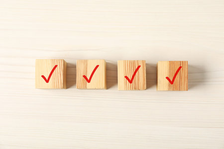 Wooden cubes with check marks on table, flat lay