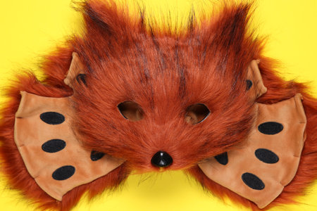 Quadrobics. Fox mask and gloves on yellow background, top viewの写真素材