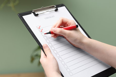 Woman filling Checklist with marker indoors, closeupの写真素材