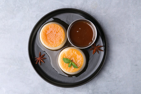 Tasty puddings with caramel sauce served on light grey table, top viewの写真素材