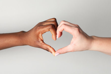 Stop racism. People of different skin colors making heart with hands on light grey background, closeupの写真素材